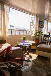 un soggiorno con tavolo e una grande finestra di Encantador cómodo y confortable. a Bogotá