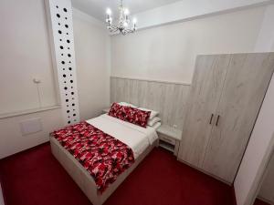 um quarto com uma cama com um cobertor vermelho em Apartmani Villa Grande em Bugojno