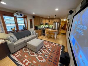 een woonkamer met een bank en een tv en een keuken bij Alberta Arts Craftsman ADU in Portland