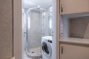 a bathroom with a shower and a washing machine at Penthouse in the heart of Athens in Athens