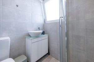 a white bathroom with a sink and a shower at Penthouse in the heart of Athens in Athens