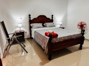 Un dormitorio con una cama con un osito de peluche. en Villa Esperança, en Tarrafal