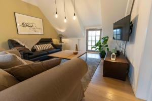 uma sala de estar com um sofá e uma televisão em Wit Peerd Guesthouse em Londerzeel