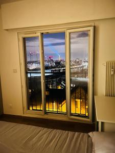 Schlafzimmer mit einem großen Fenster mit Stadtblick in der Unterkunft Belle Vue in Meudon