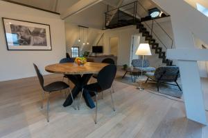 - une salle à manger et un salon avec une table et des chaises dans l'établissement Wit Peerd Guesthouse, à Londerzeel