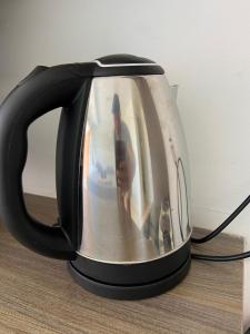 a black tea kettle with a picture of a person at Los primos in Búzios