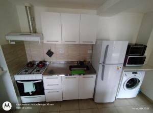 a kitchen with a white refrigerator and a washer at Mirando al Sol Ushuaia in Ushuaia