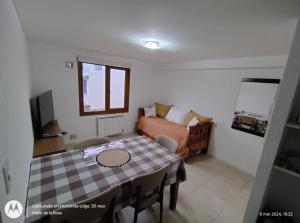 a living room with a table and a couch at Mirando al Sol Ushuaia in Ushuaia