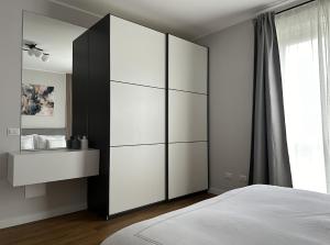 um quarto com um grande armário branco e uma cama em The Captain's Apartments Marina - next to Verbella - Leonardo Academy, MXP em Sesto Calende