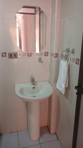 uma casa de banho com um lavatório branco e um espelho. em Hostal Beds of salt Ga em Uyuni