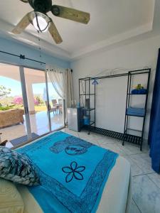 a bedroom with a bed with a blue blanket at Tucanes Ridge Bed and Breakfast in Tarcoles