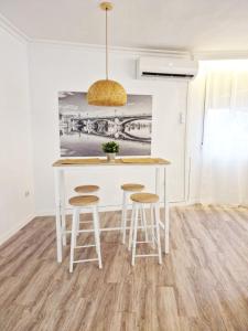 a kitchen with a white table and stools at Evangelista59 in Seville