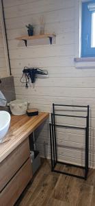a bathroom with a sink and a wooden counter with a counter at Domek Skitnica in Mirsk