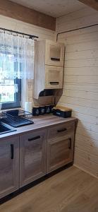 a kitchen with wooden cabinets and a counter top at Domek Skitnica in Mirsk