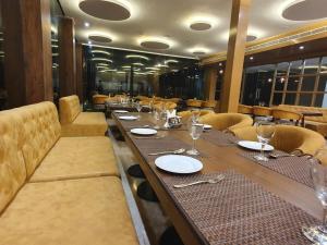 a dining room with a long table and chairs at The Moziac Hotel in Gwalior