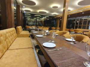 a dining room with a long table and chairs at The Moziac Hotel in Gwalior