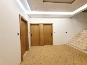 an empty room with stairs and wooden doors at The Moziac Hotel in Gwalior