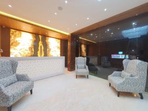 a lobby with two chairs and a table and a television at The Moziac Hotel in Gwalior