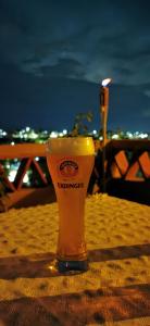 een glas bier op een tafel op het strand bij Casa Donaji in Oaxaca City