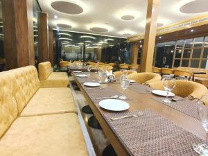 a dining room with a long table and chairs at The Moziac Hotel in Gwalior +11 photos