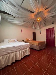 a bedroom with two beds and a ceiling at Hostal Lenha in Concepción de Ataco