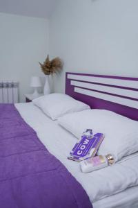 a purple and white bed with a thermometer on it at Restland Dilijan Family Hotel in Dilijan