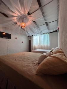 a bedroom with a bed with a white ceiling at Hostal Lenha in Concepción de Ataco