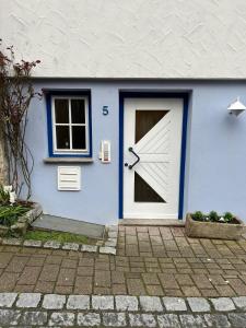 a blue house with a door with a clock on it at Ferienwohnung Forchtenberg in Forchtenberg