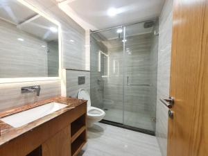 a bathroom with a shower and a toilet and a sink at The Moziac Hotel in Gwalior