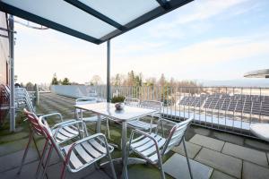 eine Terrasse mit einem Tisch und Stühlen auf dem Balkon in der Unterkunft Hotel am Kreisel Self-Check-In by Smart Hotels in Lachen