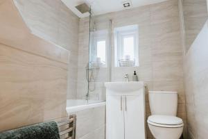 La salle de bains est pourvue de toilettes, d'un lavabo et d'une baignoire. dans l'établissement 3 Bed - Modern Comfortable Stay - St Helens Town Centre, à St Helens