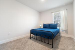 um quarto com uma cama com lençóis azuis e uma janela em Admiral's Quarters Suite em Pensacola