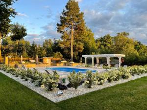 a garden with a swimming pool and a gazebo at Villa Elise Park Pension in Stronie Śląskie