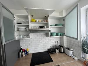 a kitchen with white walls and white shelves at O'Rits Paris - Magnifique appartement proche Paris in Rueil-Malmaison