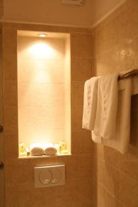 a bathroom with a shower with a mirror and towels at Hotel Villa Viktorija in Banja Luka