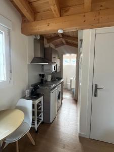a kitchen with a stove and a table with chairs at Apartamentos Sierra in Ezcaray