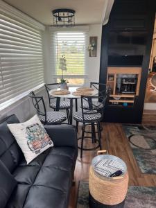a living room with a couch and a table with chairs at Rustic Farm meadow stay in Temecula
