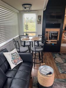 een woonkamer met een bank en een tafel met stoelen bij Rustic Farm meadow stay in Temecula