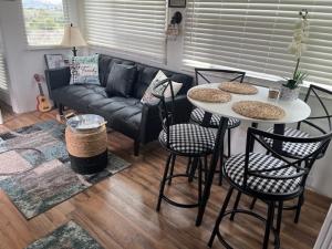 a living room with a couch and a table and chairs at Rustic Farm meadow stay in Temecula
