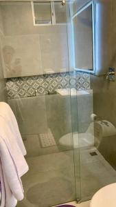 y baño con ducha de cristal y aseo. en Microsuite 1 hermosa y privada, en Guayaquil