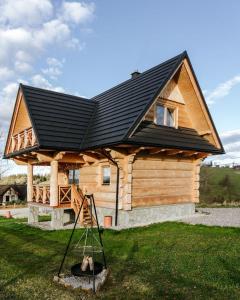 a house with a black roof on top of it at Chałpy Pod Ostryszem in Ciche