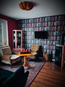 una sala de estar con una gran pared de libros en Schwarze Möwe, en Grambin