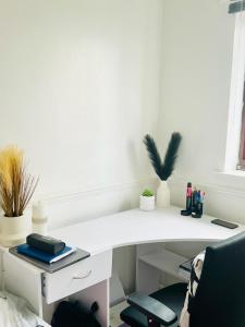 a white desk with a chair in a room at Quiet Single bedroom with free parking, office desk &chair, free wifi in Harrowden