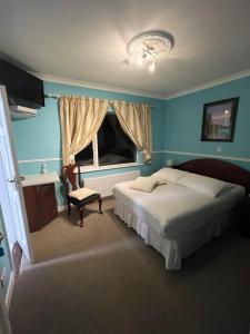 - une chambre avec un lit, une chaise et une fenêtre dans l'établissement Kinsale B&B, à Scilly