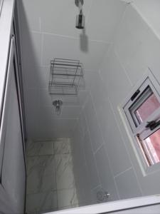 a bathroom with a walk in shower and a window at INGA in Ituzaingó