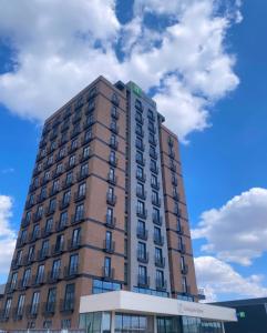 a tall brown building with clouds in the sky at Holiday Inn Express - Ankara - Airport by IHG in Ankara