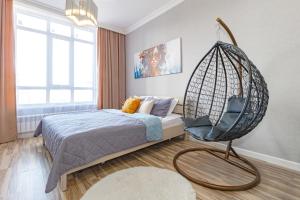 a bedroom with a swinging bed and a swing chair at Apart Astana, PARASAT 53, Ботанический сад, Хан-Шатыр in Astana