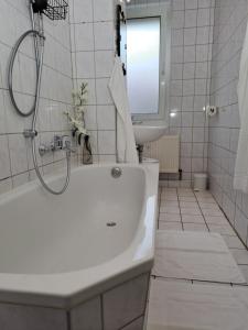 a white bathroom with a tub and a sink at BurgK59, 3 BR, 4 Beds, TV, Kitchen and Bath in Muldenstein +20 photos