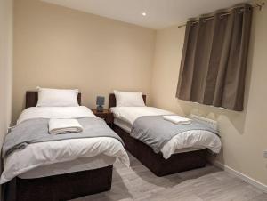 a bedroom with two beds and a window at Newly Launched Two Bedroom House By Den Accommodation Short Lets & Serviced Accommodation With Garden in London