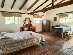 a bedroom with a bed and a refrigerator and a table at Casona Don Giovanni in Lamay